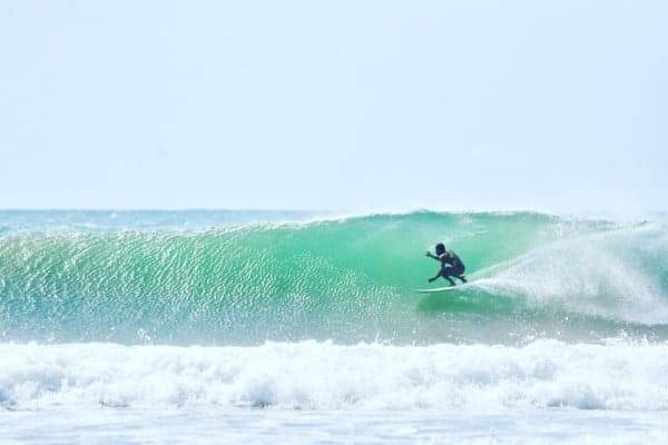 A surfer riding a hollow green wave at Arugam Bay on Sri Lanka's east coast