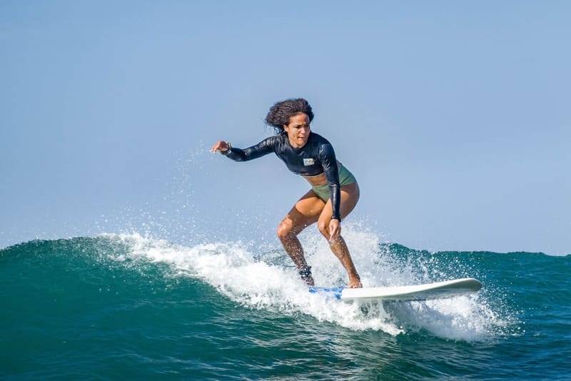 Eine fortgeschrittene Surferin fährt eine saubere grüne Welle in der Weligama Bay, Sri Lanka