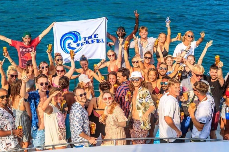 Guests holding The Surfer camp flag on the sunset boat party off Weligama, Sri Lanka