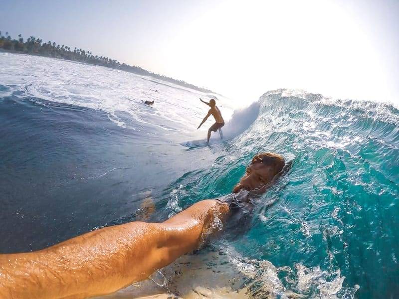 Point-of-View-Aufnahme vom Surfboard, während ein anderer Surfer dieselbe Welle fährt — Surf-Etikette in der Praxis