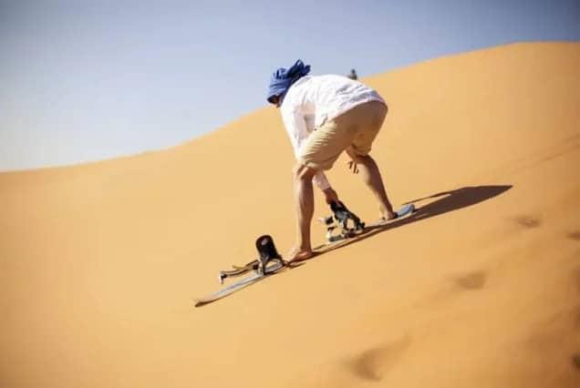 Ein Sandboarder fährt eine Düne bei Taghazout hinunter, Marokko