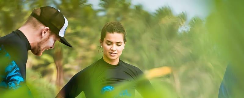 Ein Surflehrer von The Surfer und ein Gast in Lycras vor einer Surfsession in Weligama, Sri Lanka